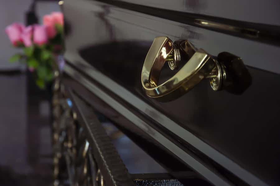 Dark wood coffin with gold handles