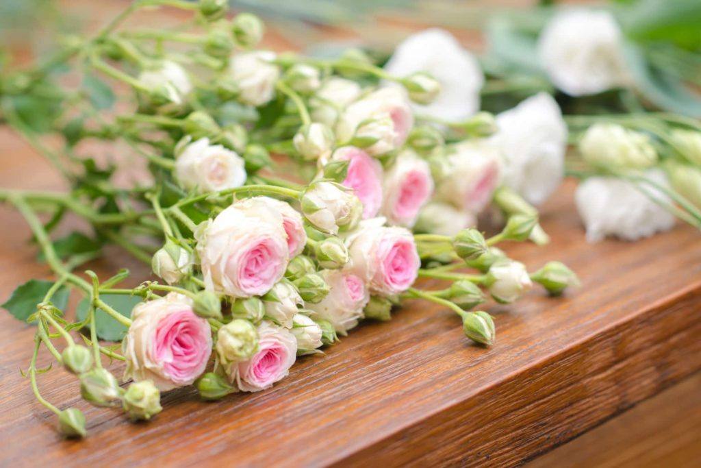 white and pink flowers on coffin